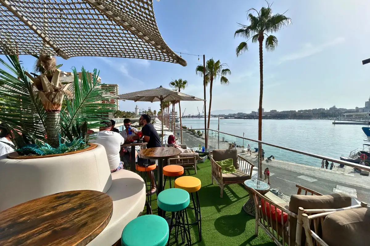 Colourful stools and lounge seating with harbour views at Nusa, Muelle Uno, Malaga