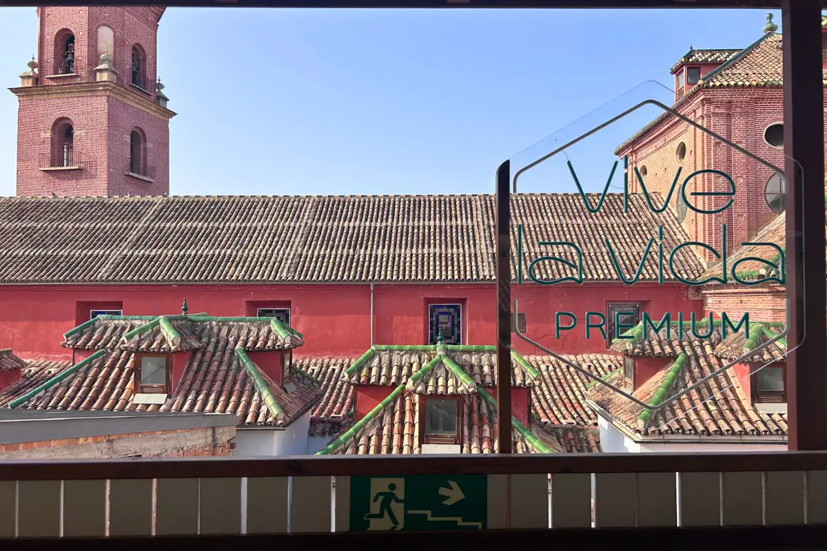 Red church facade and tiled rooftops viewed from La Terraza de San Telmo in Malaga